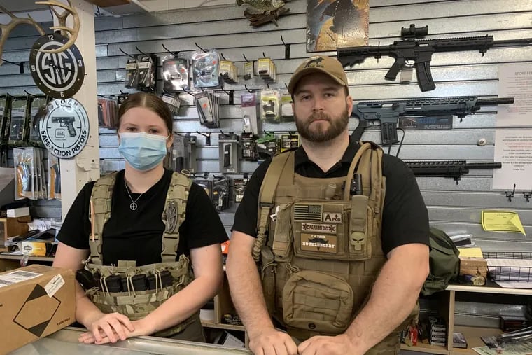 William, who owns Founding Fathers Outfitters, a gun shop in Montgomery County, stands next to his employee, Patricia, Tuesday. They do not want their last names used for fear of violence. William sleeps in the store every night since an attempted break-in Sunday morning. He spends the night in an office chair or on the floor. Patricia is in a sleeping bag. They sold as many guns in three weeks than they do in a year.