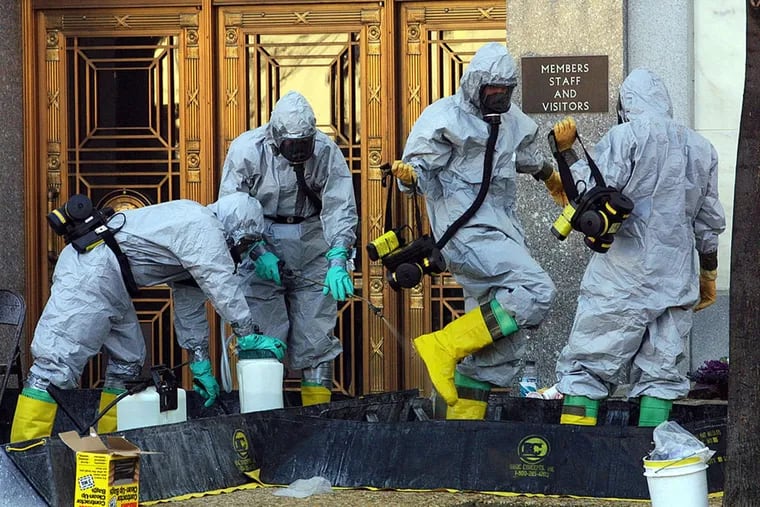 A hazardous material worker sprays his colleagues after they came out from an anthrax search at Dirksen Senate Office Building November 18, 2001 on Capitol Hill in Washington, D.C.