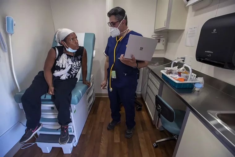 A patient speaks with a doctor inside a mobile clinic in Sept. 26 in Los Angeles.
