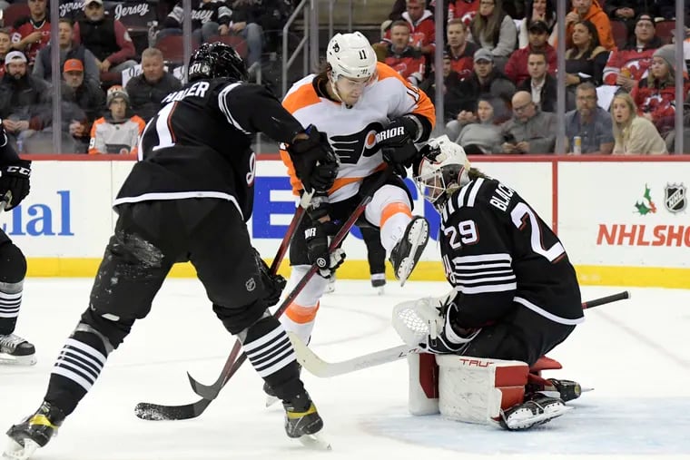 New Jersey Devils goaltender Mackenzie Blackwood (29) makes a save as he is screened by Philadelphia Flyers right wing Travis Konecny (11) during the second period of an NHL hockey game Wednesday, Dec. 8, 2021, in Newark, N.J. (AP Photo/Bill Kostroun)