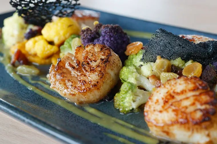 The scallops with bacon lardons, cauliflower, romanesco, squash purée, plumped raisins and verjus vinaigrette from The Lookout Restaurant at the Cape May Ferry Terminal in North Cape May on June 17, 2022.