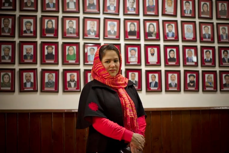 In this Monday, March 17, 2014 file photo, Afghan lawmaker Fawzia Koofi from Kabul poses next to the picture wall showing Afghanistan's 249 parliamentarians in the parliament in Kabul, Afghanistan.