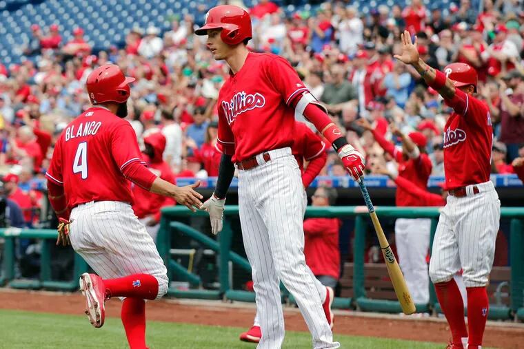 The Phillies' Andres Blanco celebrates his third-inning run with teammate Tyler Goeddel and Cesar Hernandez against the Miami Marlins on Wednesday, May 18, 2016, in Philadelphia.