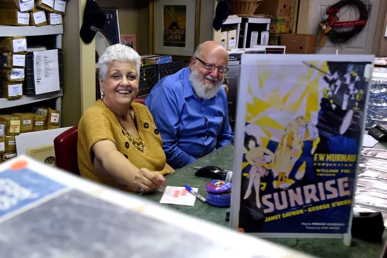 Carol and Ralph Secinaro in their "Movie Poster and Book Shop" in Barrington on September 4, as they prepared to officially reopen their 'died and went to heaven' retail store for movie geeks of all ages. In foreground is a rare lobby card from Ralph's favorite movie of all time, the 1927 silent film, "Sunrise (A Song of Two Humans)" by F.W. Murnau.