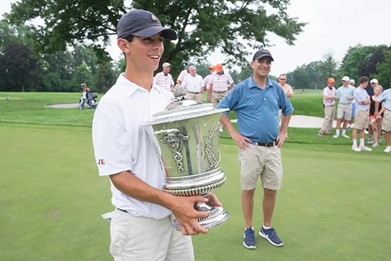 Cole Berman defeats Michael Davis 6 and 4 in 36 hole match play to win the Philadelphia Amateur golf championship at Llanerch Country Club. Here, Cole Berman holds his trophy as his father Peter proudly looks on.( ED HILLE / staff photographer )