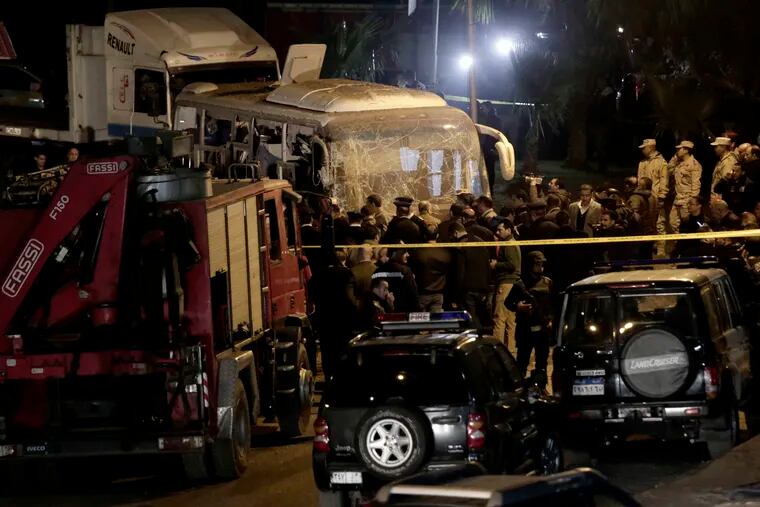 Security forces stand near a tourist bus after a roadside bomb in an area near the Giza Pyramids in Cairo, Egypt.  Egypt's Interior Ministry said in a statement that two Vietnamese tourists were killed and others wounded, in the incident.