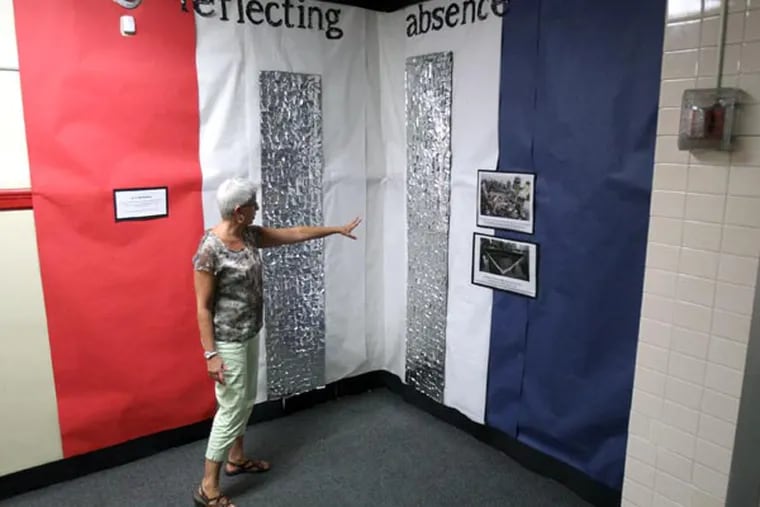 Art teacher Margaret LaDue looks at the completed "Reflecting Absence" to mimic the name of the 9/11 memorial in NYC where there are two pools of water in the footprint of the two towers. The 500 students at Paulsboro High School are creating a 9/11 memorial in the main hallway outside of the cafeteria, September 10, 2013.  ( DAVID M WARREN / Staff Photographer )