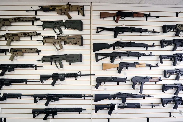 In this Oct. 2, 2018, semi-automatic rifles fill a wall at a gun shop in Lynnwood, Wash. Starting Tuesday, Jan. 1, 2019, no one under the age of 21 in Washington state will be allowed to purchase a "semi-automatic assault rifle," under a voter-approved initiative that passed in November. (AP Photo/Elaine Thompson)
