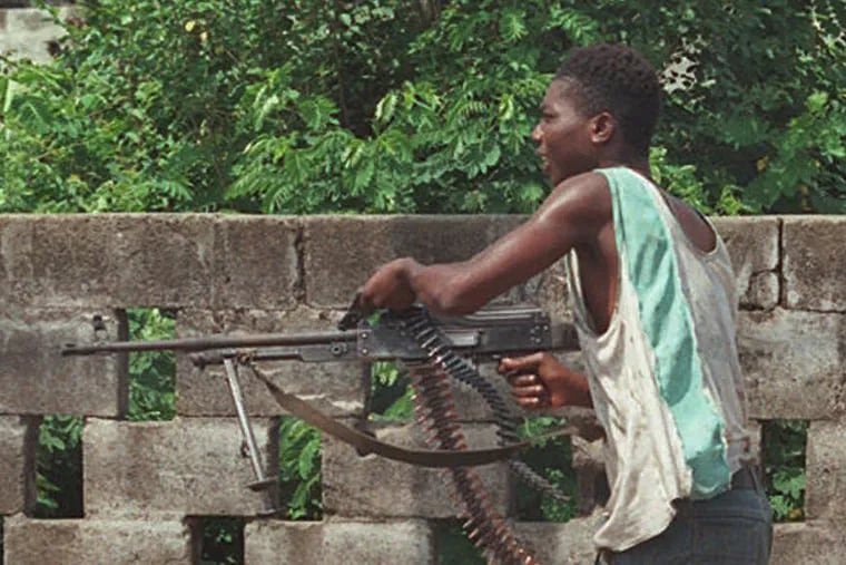 Liberian factional fighters loyal to Charles Taylor's National Patriotic Front of Liberia (NPFL) fire a high caliber machine guns at rival fighters in downtown Monrovia in 1996.