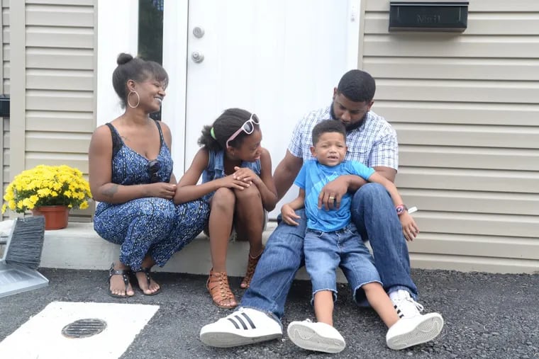 Danielle Gray, daughter Cameron,  son Shane, and father Dustin at the back entrance of their new Habitat for Humanity home.