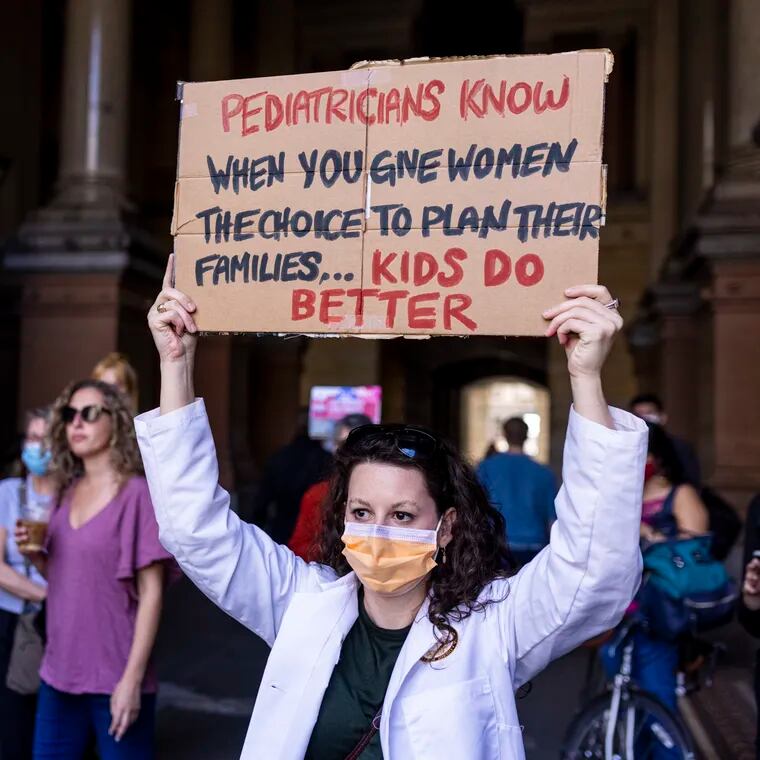 Jennifer Lehmberg, MD at CHOP, holds sign in front of a crowd during the 2021 Women’s March.