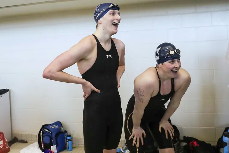 Penn’s Lia Thomas, left, and Yale’s Iszac Henig react after they both qualified for the 100-yard freestyle finals race on March 19, 2022, which Thomas said was the highlight of the NCAA finals experience.