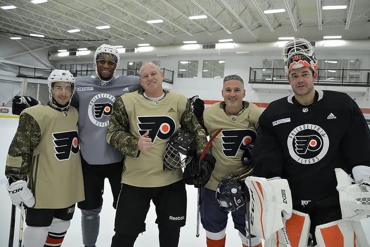 Flyers’ Wayne Simmonds (second from left) and Brian Elliott (far right) pose with some Air Force members on Monday. Elliott’s wife, Amanda, once served in the Air Force.