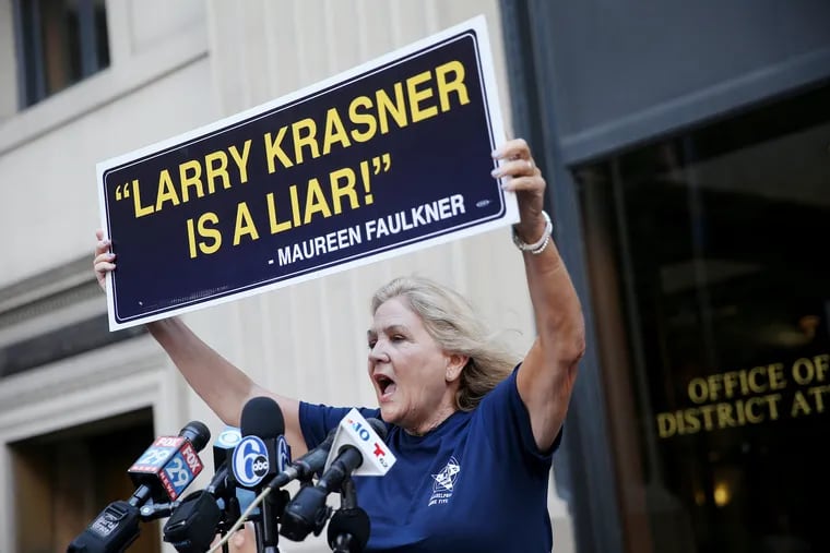 Maureen Faulkner, widow of murdered Philadelphia Police Officer Daniel Faulkner, holds up a sign criticizing District Attorney Larry Krasner outside Krasner's office in Center City Philadelphia on Friday, Oct. 4, 2019.