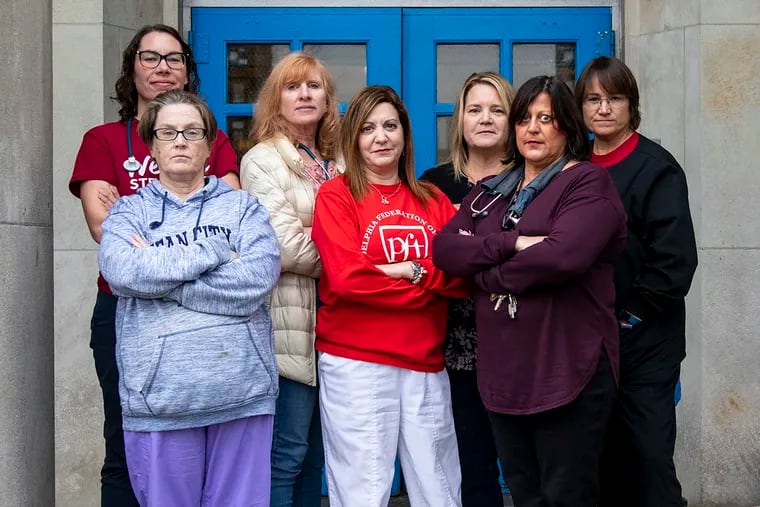 From left to right, Emily Seiter, 33, of West Philadelphia, school nurse at Alexander McClure, Colleen Kennedy, 54, of Drexel Hill, Pa., school nurse at Widener Memorial, Anne Smith, 60, of Wissahickon, Pa., school nurse at The Philadelphia High School For Girls, Michele Perloff, 55, of Philadelphia, school nurse at Albert M. Greenfield Elementary, Patricia Melloy, 50, of Northeast Philadelphia, school nurse at Wilson Middle School, Susan Cook, 57, of Ben Salem, Pa., school nurse at George Washington High School, and Lori Kramer, 49, of Philadelphia, school nurse, pose for a portrait in front of the entrance of The Philadelphia High School For Girls on Friday.