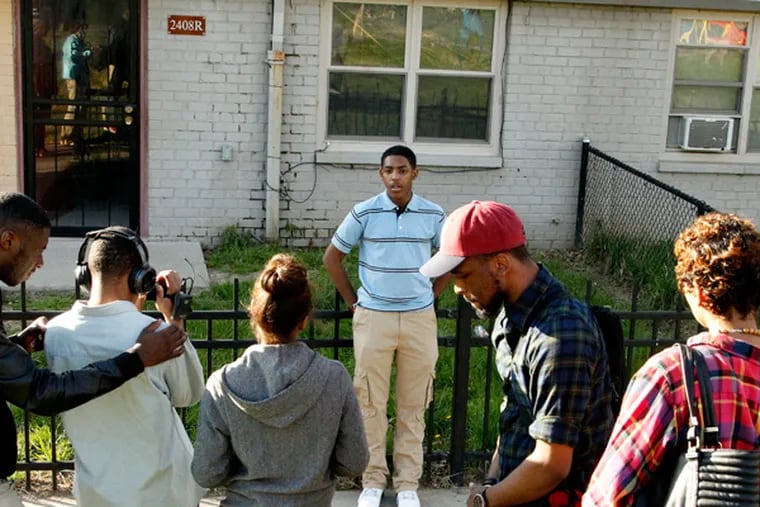 Nasir Smith, center, being filmed by Darren Wyes-Nunez  while Terence Lewis, on the left checks things out. Nasir didn't hesitate when asked to describe his neighborhood: "Hell. It's Hell." (RON CORTES/Staff Photographer)