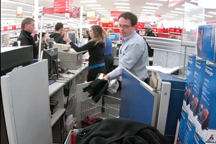 Store employee John Floryan, center, puts returns into a shopping cart at the Wilkes-Barre Twp, Pa. Kmart Monday, Dec. 26, 2011. (AP Photo/The Citizens' Voice, Mark Moran)  MANDATORY CREDIT