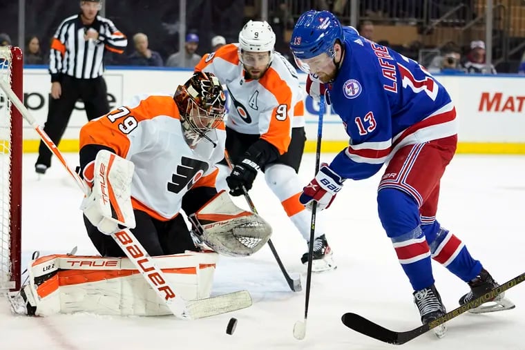 Philadelphia Flyers goaltender Carter Hart (79) and defenseman Ivan Provorov (9) tend the net against New York Rangers left wing Alexis Lafreniere (13) during the second period of an NHL hockey game, Wednesday, Dec. 1, 2021, at Madison Square Garden in New York. (AP Photo/Mary Altaffer)