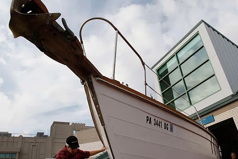 Bob Fagen helps maneuver a 38-foot wooden boat at Workshop on the Water at Independence Seaport Museum.