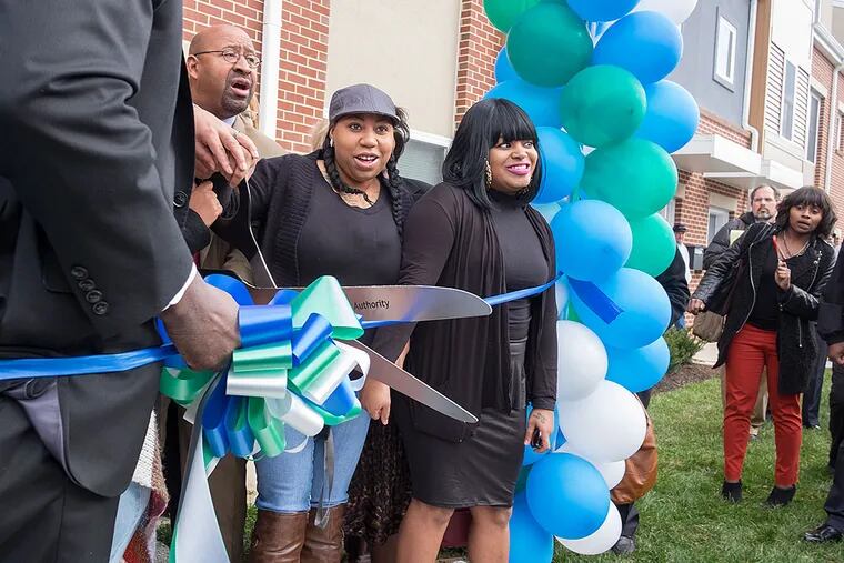 New Queen Lane residents Shaqueia Johnson (center) and Jenise Davis join Mayor Nutter and Philadelphia Housing Authority officials for a ribbon-cutting ceremony.