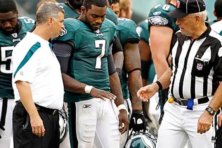 Eagles quarterback Michael Vick examines his right hand, which X-rays proved to be broken. (Ron Cortes/Staff Photographer)