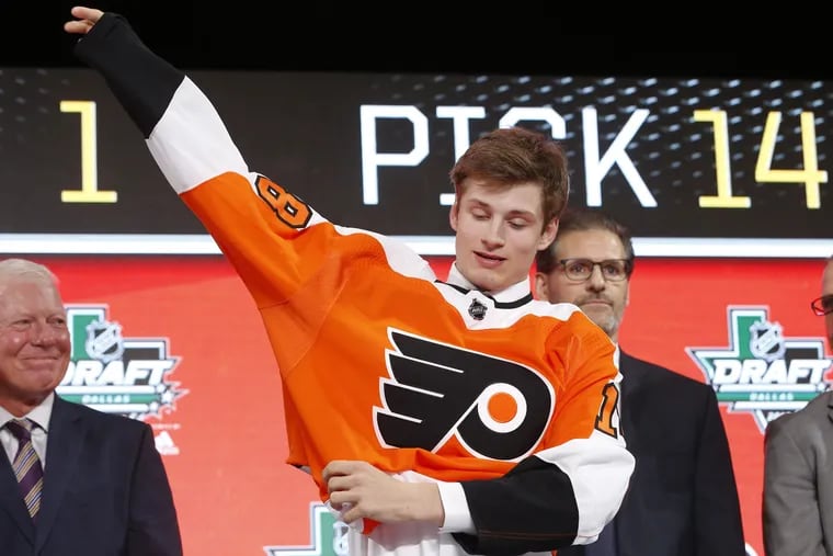 Left winger Joel Farabee, with then-GM Ron Hextall behind him, puts on a jersey after being selected by the  Flyers in the first round in the 2018 draft. He was one of five Americans drafted by the Flyers.