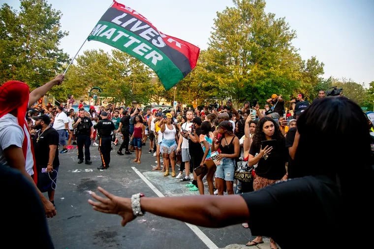 Protesters clear a path so police can escort Edward Cagney Mathews through the crowd that gathered outside his Mount Laurel home on Monday. The crowd converged after a video went viral showing Mathews shouting racial slurs and offensive language at his neighbors.