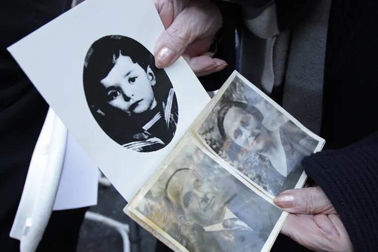 Holocaust survivor Clara Vinokur, of Northeast Philadelphia, displays photos of her mother, father, and brother who were killed during the Holocaust. Vinokur attended the annual Memorial Ceremony for the Six Million Jewish Martyrs in Philadelphia on April 27, 2014. It marked the 50th anniversary of the dedication of the monument. (DAVID MAIALETTI/Staff Photographer)