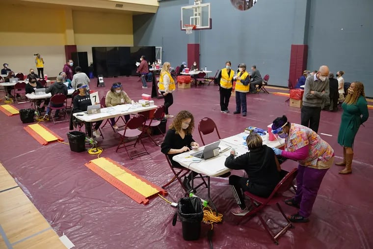 Health-care workers administer vaccines at a community COVID-19 vaccination clinic run by the Philadelphia Department of Public Health at University of the Sciences' Bobby Morgan Arena in West Philadelphia on Saturday.