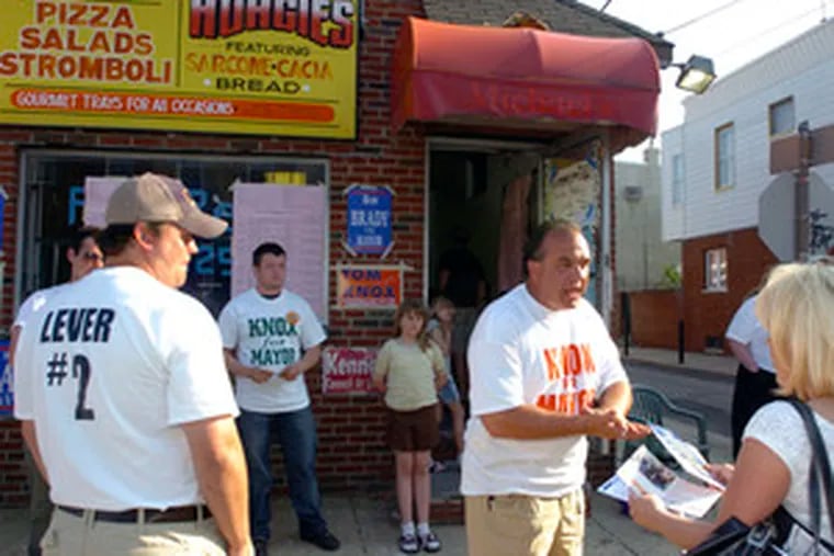 Frank D'Adamo (center) debates issues at polling place at Wolf and Hutchinson streets, South Philadelphia.