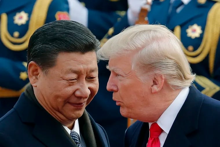 In this Nov. 9, 2017, file photo, U.S. President Donald Trump, right, chats with Chinese President Xi Jinping during a welcome ceremony at the Great Hall of the People in Beijing.
