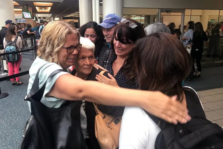 Leonor Figueroa, 82, center, a survivor of Hurricane Maria, is surrounded by her daughters after arriving Tuesday at the Orlando airport from Puerto Rico.