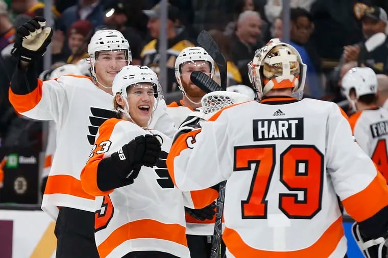 Oskar Lindblom (23) and Flyers teammates celebrate with goalie Carter Hart (79) after defeating the Boston Bruins in a shootout.
