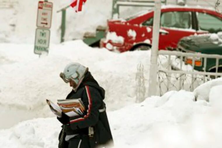 Letter carrier Adriana Hansen trudges along a street in Bath, Maine. Snow blanketed most of the state Sunday, with some regions receiving more than three feet. Story, A15.