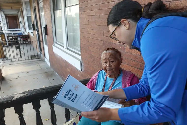 Amparo, who declined to give her last name, goes through the Philly Help Book and other resources with Vanessa Caracoza, director of community engagement for the Philadelphia Office of Community Empowerment and Opportunity, outside of Amparo’s home in North Philadelphia. Health officials say that overdoses are rising in neighborhoods in North Philadelphia, but too few people in the neighborhood are equipped to prevent them.