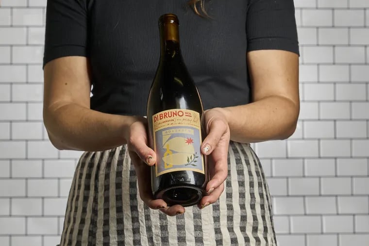 A Dolcetto from Oregon's Pray Tell, the latest in a wine collaboration series from Di Bruno Bros., is held by Sande Friedman, the beverage buyer for Di Bruno's who also had an active role in making the wine.