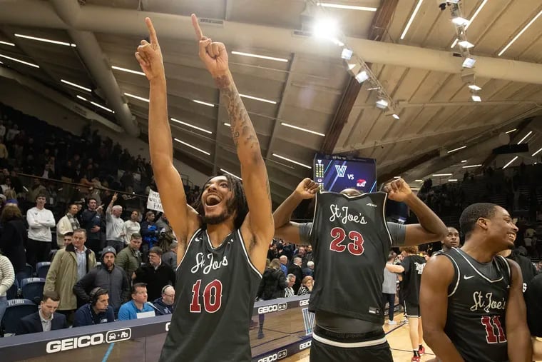 Shawn Simmons (left) and Anthony Finkley of St. Joseph's celebrate after defeating Villanova at the Finneran Pavilion on Wednesday.