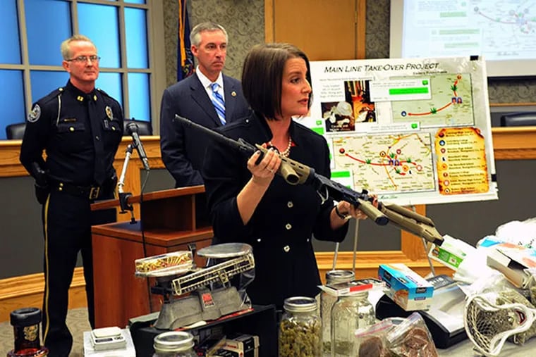 Montgomery County district attorney Risa Vetri Ferman holds an AR-15 assault rifle that was included with the drugs, guns, money and other illegal items seized when Lower Merion Police broke up a drug distribution ring dubbed the "main line take over project." ( CLEM MURRAY / Staff Photographer )