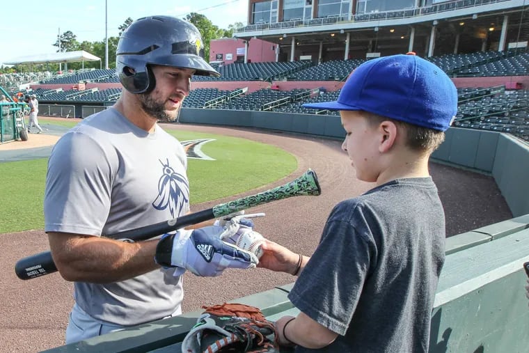 Columbia (S.C.) Fireflies' Tim Tebow signs a ball for Tyler Hunt, 9,  from Salisbury before his game with the Delmarva Shorebirds in minor-league baseball at Arthur W. Purdue Stadium in Salisbury, Md .Wednesday, May 10, 2017.