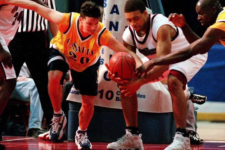 Lari Ketner (second from right), in his UMass playing days, battles for the ball with La Salle's Mike Gizzi in a 1997 game. Ketner died Friday. Inquirer File Photograph