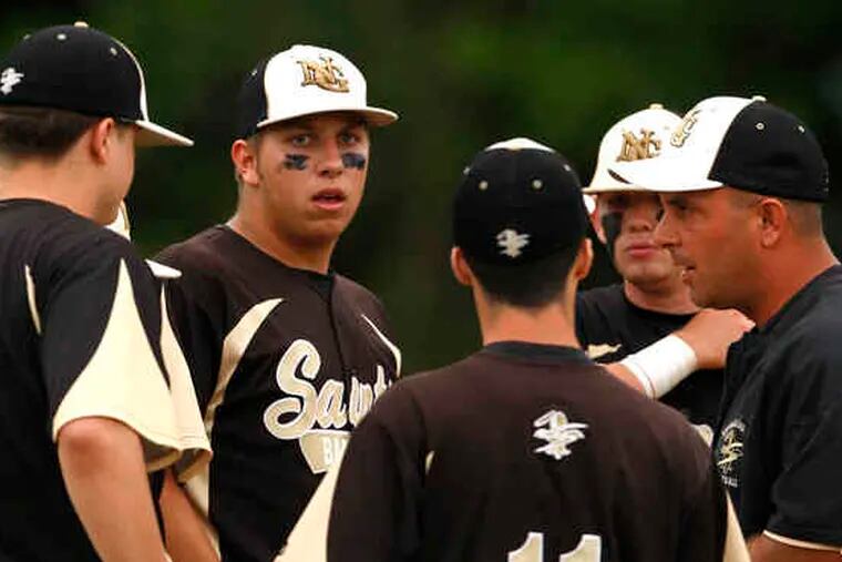 Neumann-Goretti baseball coach Lou Spadaccini (right) talks with pitcher Mark Donato (facing camera) and other members of his close-knit team.
