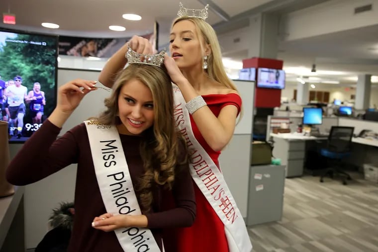 Miss Philadelphia 2019 Alysa Bainbridge, left, gets help with her tiara from Miss Philadelphia's Outstanding Teen 2019 Jaylen Baron, right, on a visit to the newsroom at The Inquirer in Philadelphia, Pa., on Tuesday, March 26, 2019.