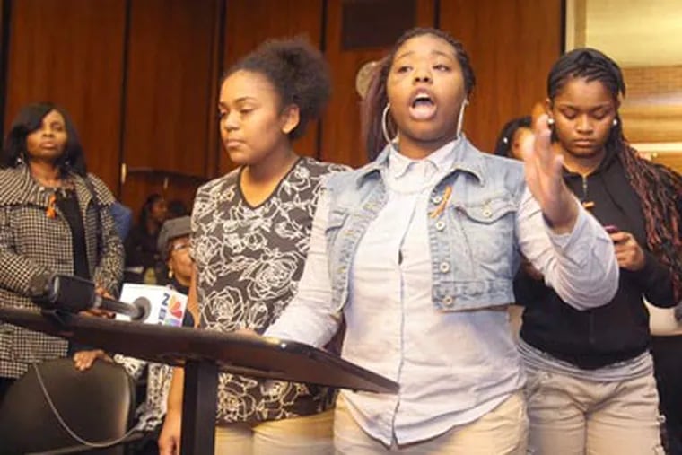 At a Chester Upland school board meeting Thursday, students including Kashay Taylor (center) spoke at the lectern despite objections from the board. (Charles Fox / Staff Photographer)