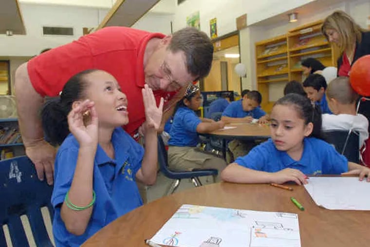 Potter-Thomas Elementary School students Lamaje Moss (left), 8, and Juniely Ortiz, 7, were asked to close their eyes and imagine what they would like to see in the school's new library, then tell Target project site representative Bill Luzar.