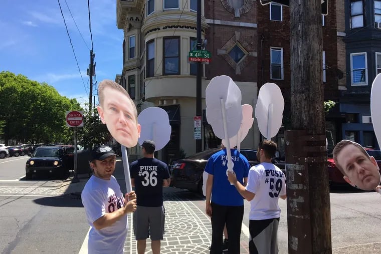 Local 98 members stand outside the Famous 4th Street Deli on primary election day, greeting Jack O’Neill with signs of support, including their trademark big-head posters.