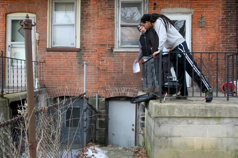Jeff Rosenblum (left) and homeowner Markese Fray (right) check for proper drainage outside of Markese Fray and Donielle Darden's home in West Philadelphia on Thursday, March 7, 2019. This is part of CHOP's pilot program that sends inspectors into homes of kids with asthma and gets the needed repairs done.