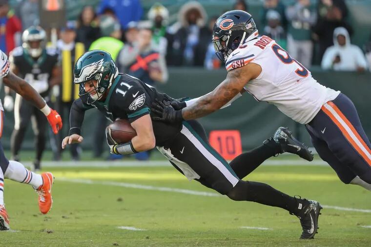 Eagle quarterback Carson Wentz, left, dives for extra yardage as the Bears' Roy Robertson-Harris tries to tackle him.