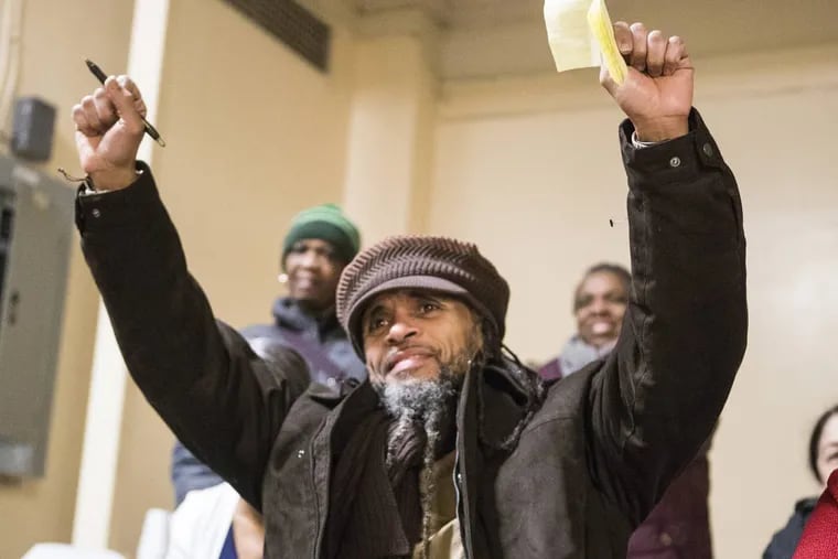 Paroled juvenile lifer Kempis “Ghani” Songster was released from Graterford State Prison Thursday morning.  He holds up his arms as he acknowledges the words of friends and relatives at a reception at Calvary Center for Culture and Community on Dec. 28, 2017.