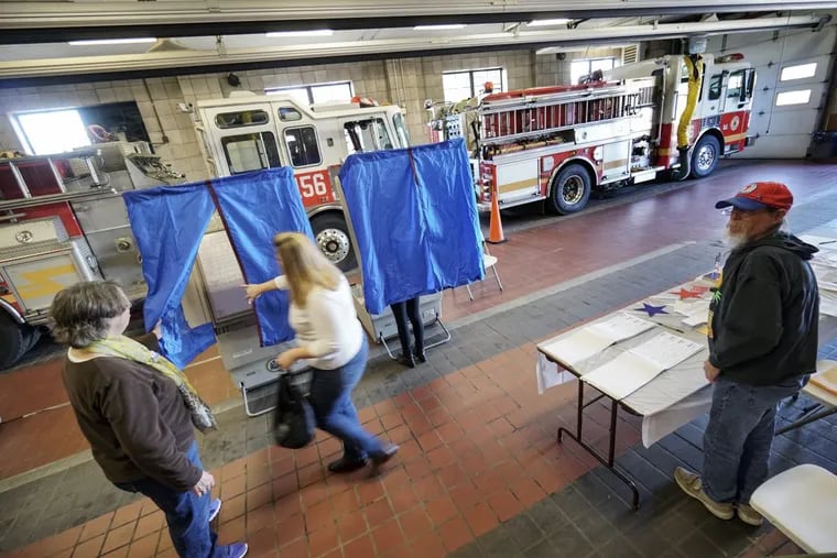 Michelle Braga enters the voting booth inside Philadelphia Fire Department’s Engine 56 firehouse.