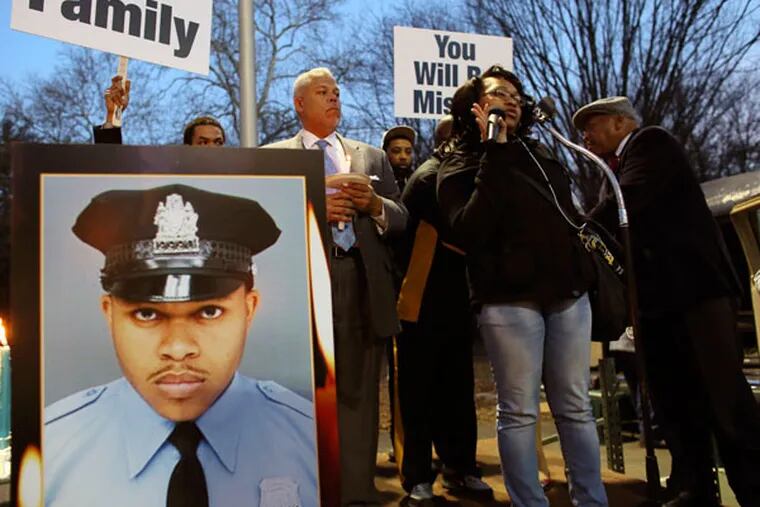 Shakira Wilson-Burroughs, holding microphone, speaks to the audience during a candlelight vigil for her brother, fallen Philadelphia Officer Robert Wilson, at a basketball court in West Philadelphia on Thursday, March 12, 2015. (Joseph Kaczmarek/For the Inquirer)